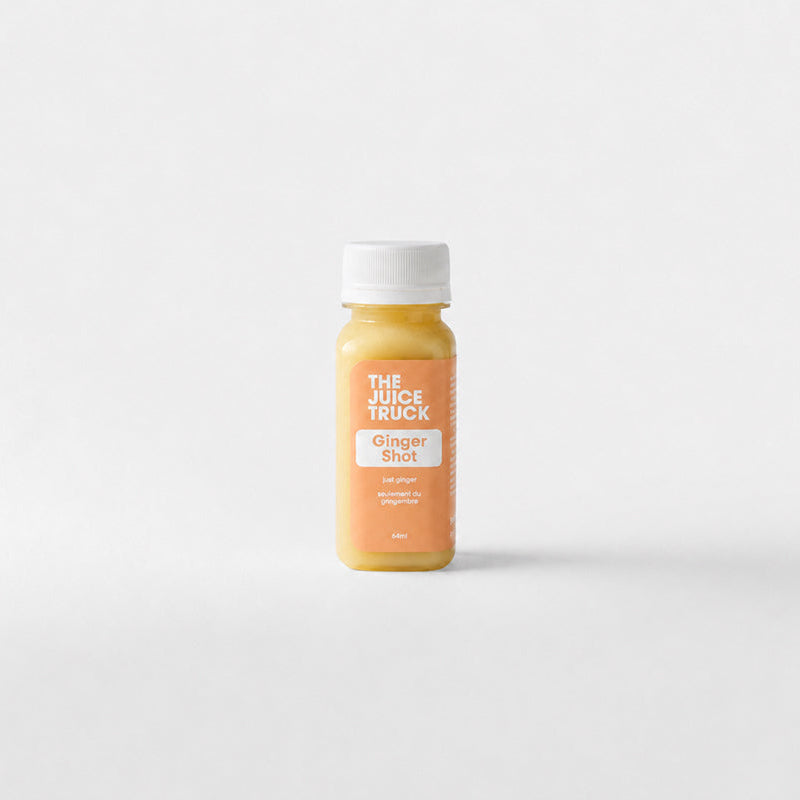 A shot bottle of ginger juice with a white cap and a light brown label reading 'THE JUICE TRUCK' on a clean white background.