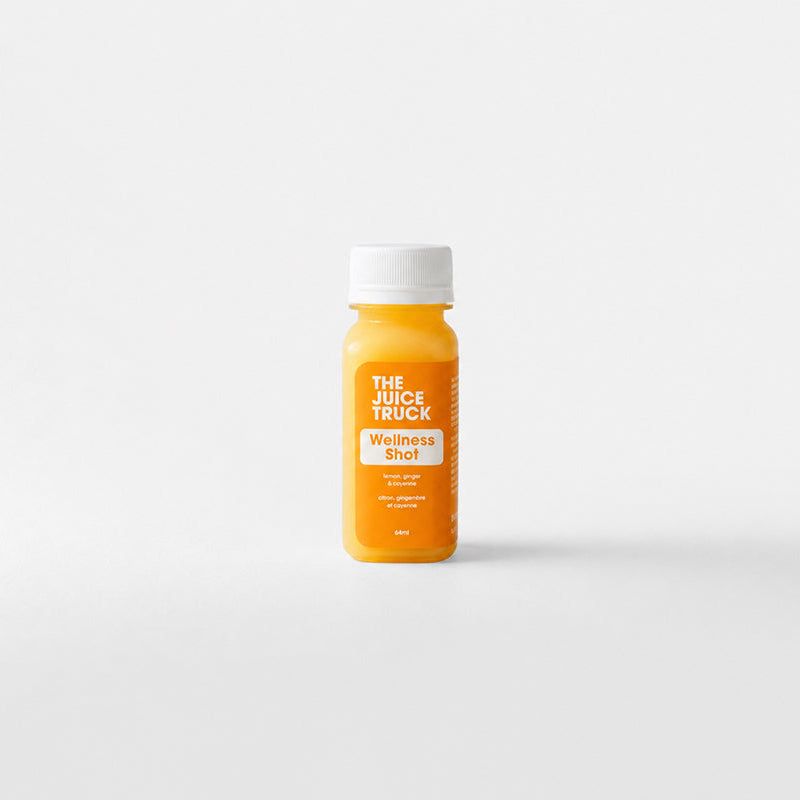 A small orange bottle with a white cap labeled 'THE JUICE TRUCK' and 'energy shot' stands centered against a clean white background.