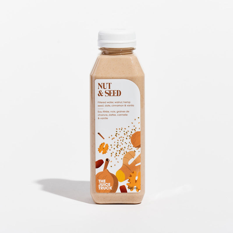 A bottle of Juice Truck brand nut mylk with images of walnut, hemp seed, date, cinnamon, and vanilla, indicating the flavours of the beverage.