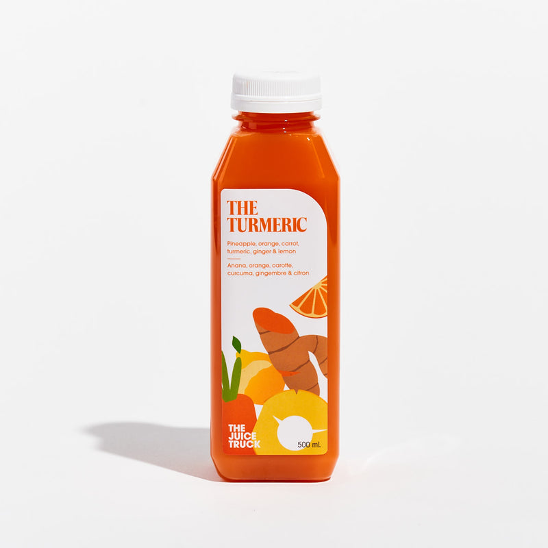 A bottle of juice labeled 'THE TURMERIC' with illustrations of pineapple, orange, carrot, turmeric, ginger, and lemon on the label.